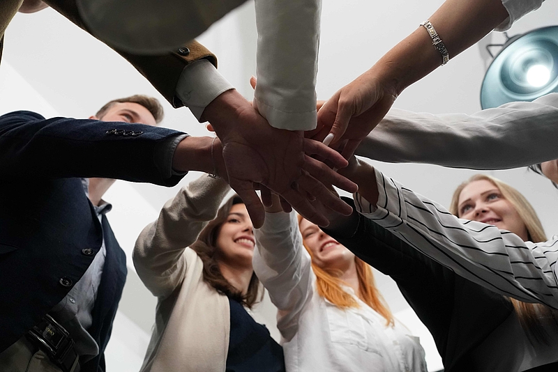 Mehrere Menschen legen Hände aufeinander