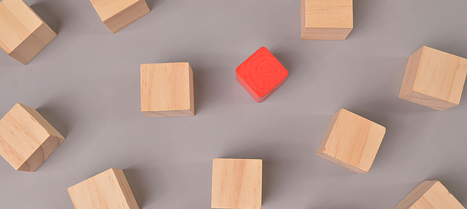 Roter Würfel in mitten von Braunen